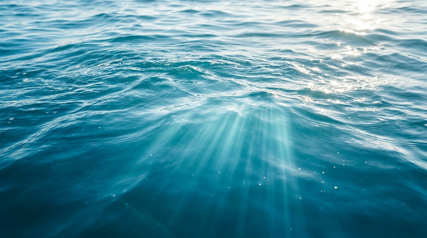 Ruhige blaue Wasseroberfläche mit Sonnenstrahlen